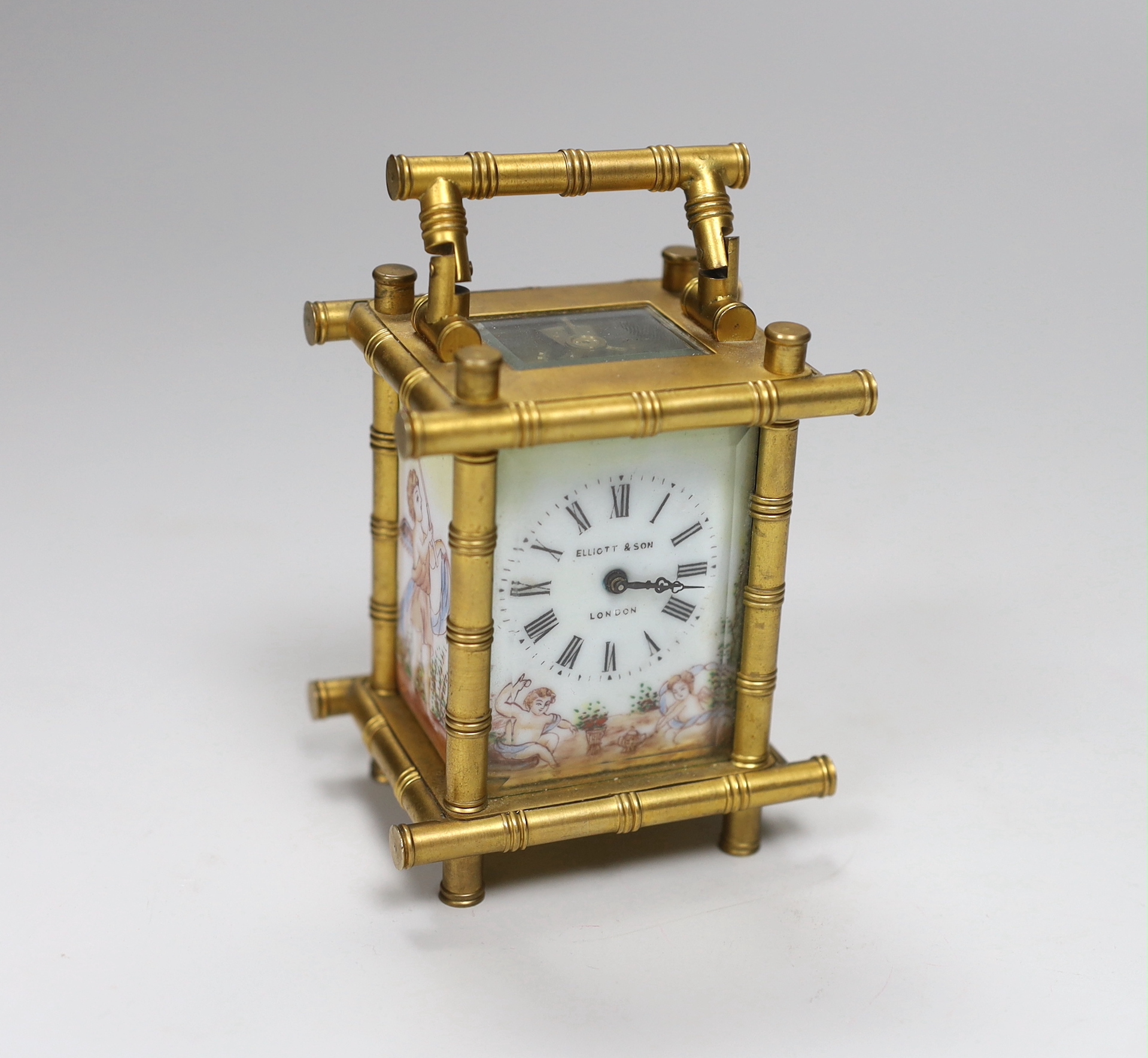 A French bamboo design carriage clock, with three porcelain putti decorated sides, by Elliot & Son, London, 9.5cm high